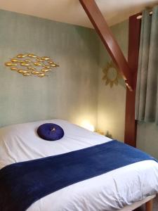 a bedroom with a bed with a blue pillow on it at Studio Mer Centre équestre in Mers-les-Bains