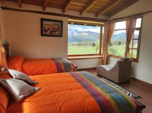 1 dormitorio con 2 camas y ventana grande en Ruta de los volcanes, en Machachi