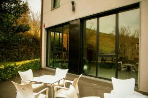 a group of white chairs and tables in front of a building at Hotel Txintxua in Hernani