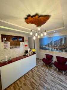 a lobby with red chairs and a reception desk at Pousada Pepone - Fortaleza Centro in Fortaleza