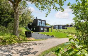 a black house on a hill with a driveway at Beautiful Home In Aabenraa With House Sea View in Aabenraa