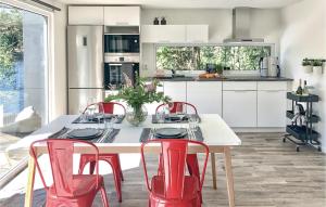 una cucina con tavolo bianco e sedie rosse di Amazing Home In Bors With Wifi a Borås