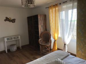 sypialnia z łóżkiem, oknem i krzesłem w obiekcie Gîte Au Petit Bonheur w mieście Saint-Savinien
