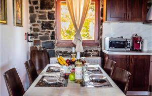 a table with chairs and a table with food on it at Amazing Home In Milatos, Lasithi With 4 Bedrooms, Private Swimming Pool And Outdoor Swimming Pool in Milatos