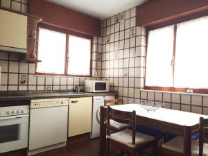 een keuken met een tafel en stoelen en een magnetron bij Casa Vasca in Llanes