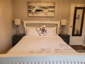 納奈莫的住宿－Campbell Cottage B&B，卧室配有带两盏灯的白色床