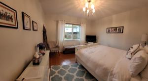 a bedroom with a white bed and a window at Campbell Cottage B&B in Nanaimo
