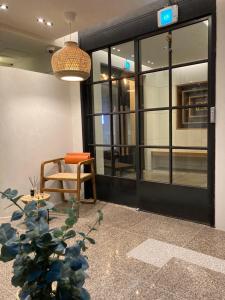 lobby biurowe z krzesłem i szklanymi drzwiami w obiekcie Hotel Less Seoul w Seulu