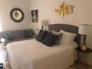 una camera con un letto bianco e un divano di Apartamento en primera línea de playa a Marbella
