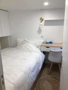 sypialnia z białym łóżkiem i biurkiem w obiekcie Duplex neuf, 15mn de Paris, parking, climatisation w mieście Bourg-la-Reine