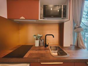 a small kitchen with a sink and a microwave at Le Chic in Ivry-sur-Seine