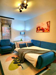 a living room with a bed and a blue couch at Angelina Apartment in Bitola