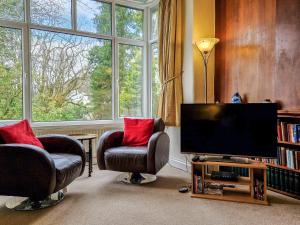 a living room with two chairs and a flat screen tv at Old Belfield in Bowness-on-Windermere