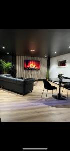 a living room with a couch and a fireplace at Loveroom Metz Spa Privatif in Metz