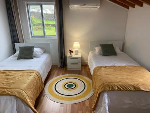 Zimmer mit 2 Betten und Zielobjekt auf dem Boden in der Unterkunft Maria's Haven in Santo António