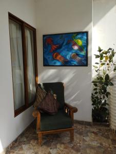 a chair in a room with a painting on the wall at Sunset Paradise in San Andrés