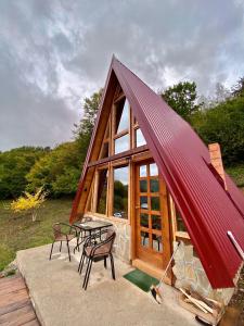 a large red roofed cabin with a table and chairs at The view in Bijelo Polje