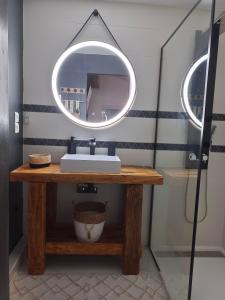 a bathroom with a sink and a mirror on a table at Maisonnette Cosy in La Llagonne
