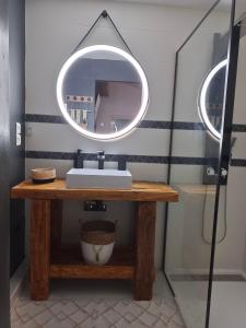 a bathroom with a sink and a mirror on a table at Maisonnette Cosy in La Llagonne +7 photos