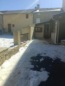 a driveway covered in snow next to a house at Maisonnette Cosy in La Llagonne
