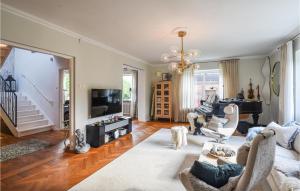 a living room with a couch and a television at Stunning Home In Gteborg With Sauna in Gothenburg