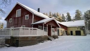 a red house with snow on the porch at Näsets Marcusgård in Furudal
