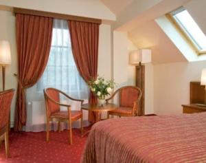 ein Hotelzimmer mit einem Bett und einem Tisch und Stühlen in der Unterkunft Garni-Hotel Kranich in Potsdam