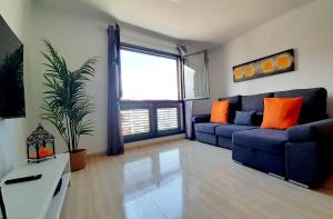 a living room with a blue couch and a large window at La Calma en Playa de Salinetas - cerca de playa y supermercado in Telde