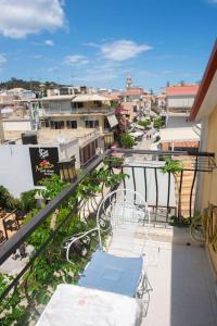 balcón con silla y vistas a la ciudad en Attic flat ''Tsoukalas Group'', en Zakynthos