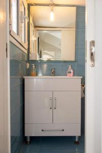 a bathroom with a white sink and a mirror at Attic flat ''Tsoukalas Group'' in Zakynthos Town