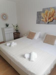 1 cama blanca grande con 2 toallas en Holiday home Filip i Petra, en Donji Proložac