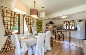 a kitchen and dining room with a white table and chairs at Nice Home In Palit With Wifi in Mundanije