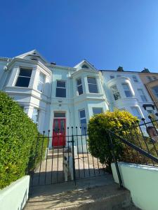 uma grande casa branca com uma porta vermelha em Loughview em Bangor