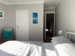 a bedroom with a white bed and a blue chair at Loughview in Bangor