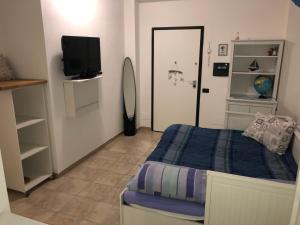 Dormitorio pequeño con cama y TV en Virgy’s House, en Sestu
