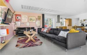 uma sala de estar com um sofá preto e uma mesa em 5 Bedroom Beautiful Home In Sjllands Odde em Yderby