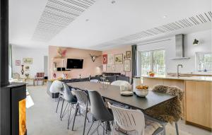 uma cozinha e sala de estar com mesa e cadeiras em 5 Bedroom Beautiful Home In Sjllands Odde em Yderby