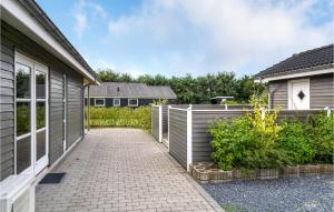a brick walkway next to a house with a fence at 3 Bedroom Lovely Home In Hemmet in Falen