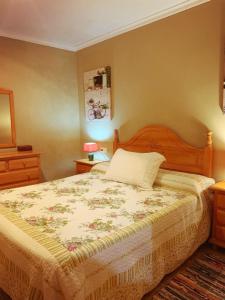 1 dormitorio con 1 cama grande con colcha de flores en CA MATI, en Serón