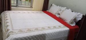 een bed met een rode en witte deken en kussens bij Beautful Home Kigali-Kanombe in Kigali