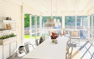 a white kitchen with a dining table and chairs at Gorgeous Home In Dalsjfors With Sauna in Dalsjöfors