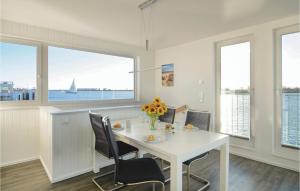 a dining room with a white table and chairs and windows at Schwimmendes Haus 24 in Olpenitz