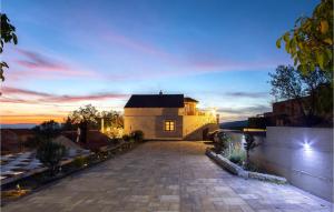 a house with a driveway in front of a sunset at Lovely Home In Lovrec With Kitchen in Lovreć