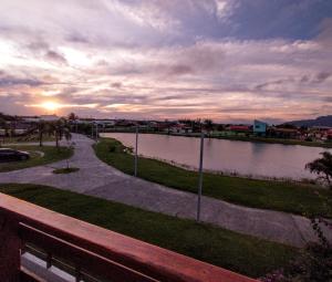 uma vista de um corpo de água com o pôr do sol em Recanto da Lagoa Flat em Ilha Comprida