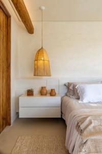 a bedroom with a bed and a pendant light at Casa Capim Cidró in Alto Paraíso de Goiás