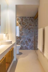 a bathroom with a stone wall at Casa Capim Cidró in Alto Paraíso de Goiás +14 photos