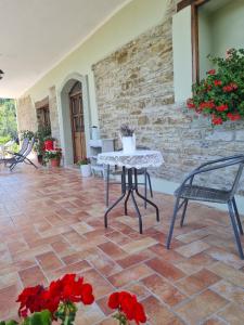 a patio with a table and two chairs and flowers at Agriturismo Il Noce d'Oro in Borgo Val di Taro
