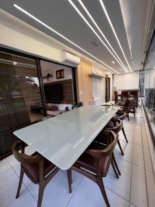 uma grande mesa branca e cadeiras num quarto em Mandara Lanai Apartamento Bangalô em Aquiraz