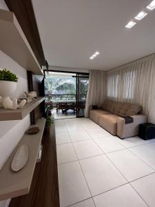 uma grande sala de estar com uma cama e uma mesa em Mandara Lanai Apartamento Bangalô em Aquiraz