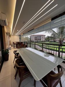 uma grande mesa de vidro num quarto com cadeiras em Mandara Lanai Apartamento Bangalô em Aquiraz